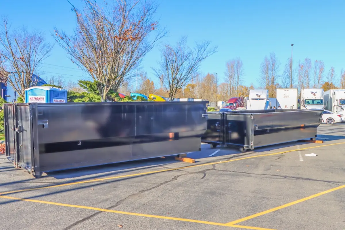 Professional dumpster rental service with roll-off container on residential driveway in Manassas Park